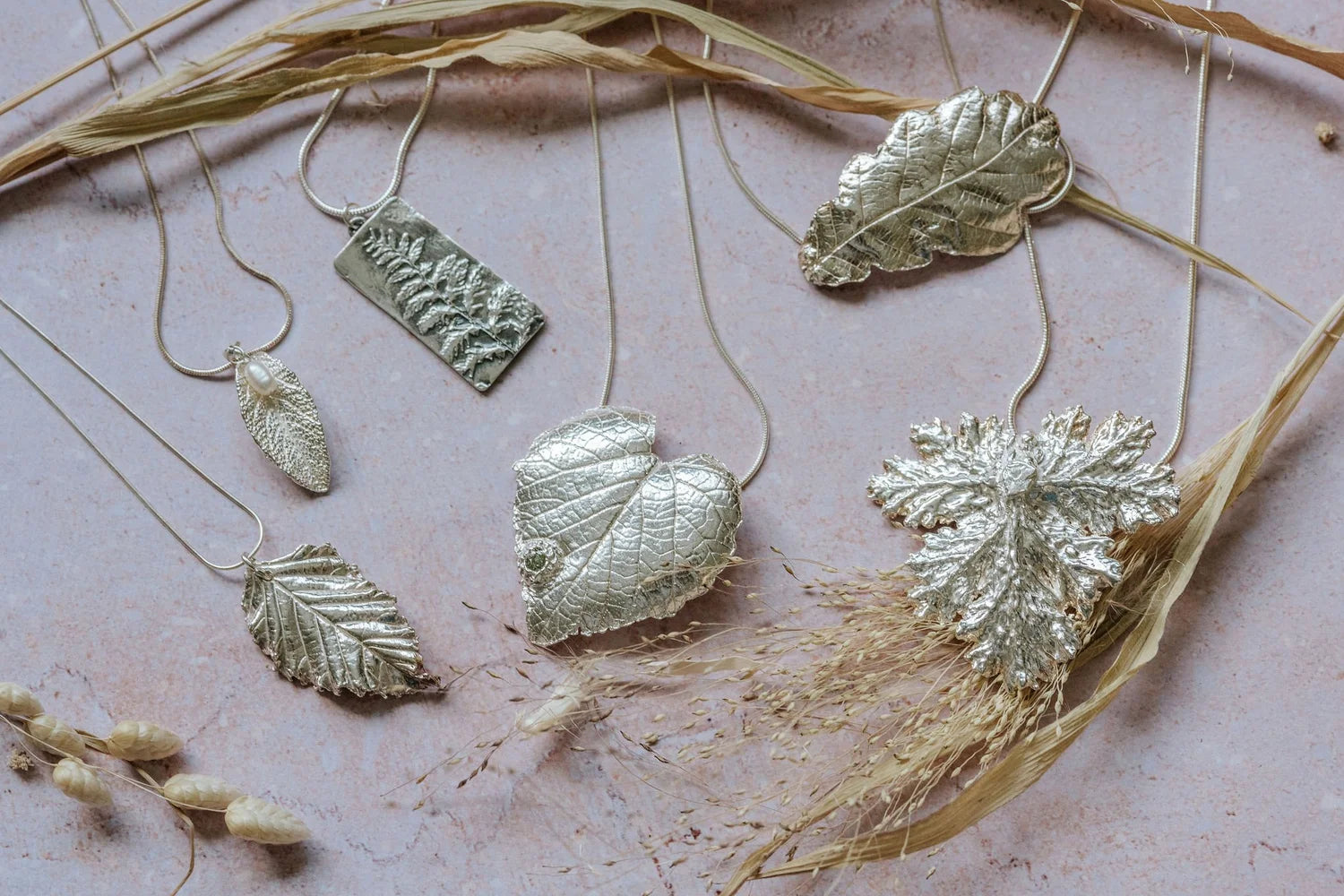 Nature-inspired silver leaf necklaces styled with dried grasses, sustainable handmade jewellery with botanical textures