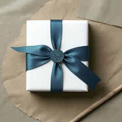 Elegant white jewellery gift box with teal satin ribbon and wax seal featuring dragonfly design, showcasing luxury packaging for handmade silver jewellery.