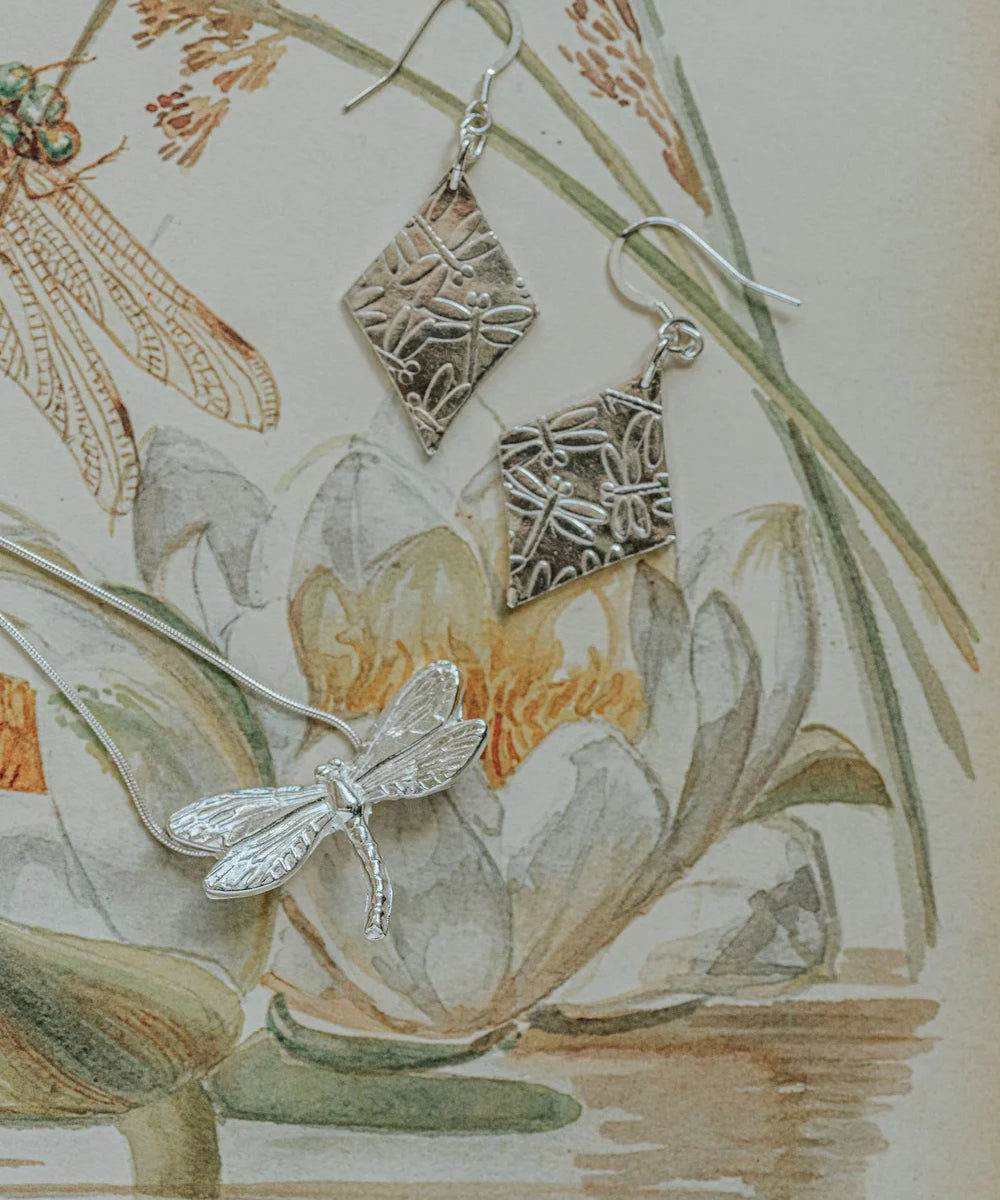Dragonfly Necklace 2 displayed with silver dragonfly earrings on vintage botanical illustration, artisan nature inspired jewellery gift UK