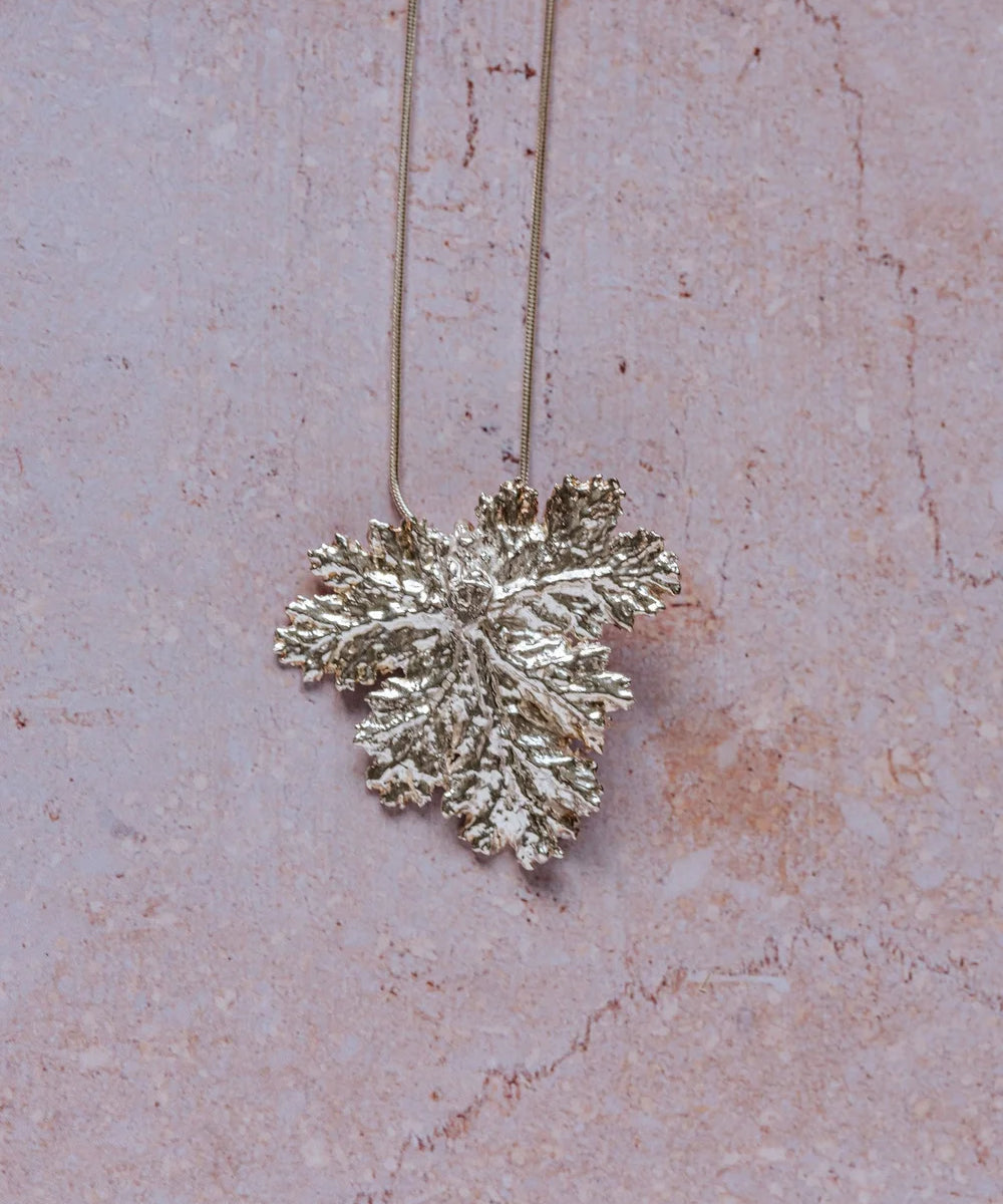 Handcrafted fine silver geranium leaf pendant necklace with intricate natural texture, inspired by Victorian floral symbolism of friendship and gentility.