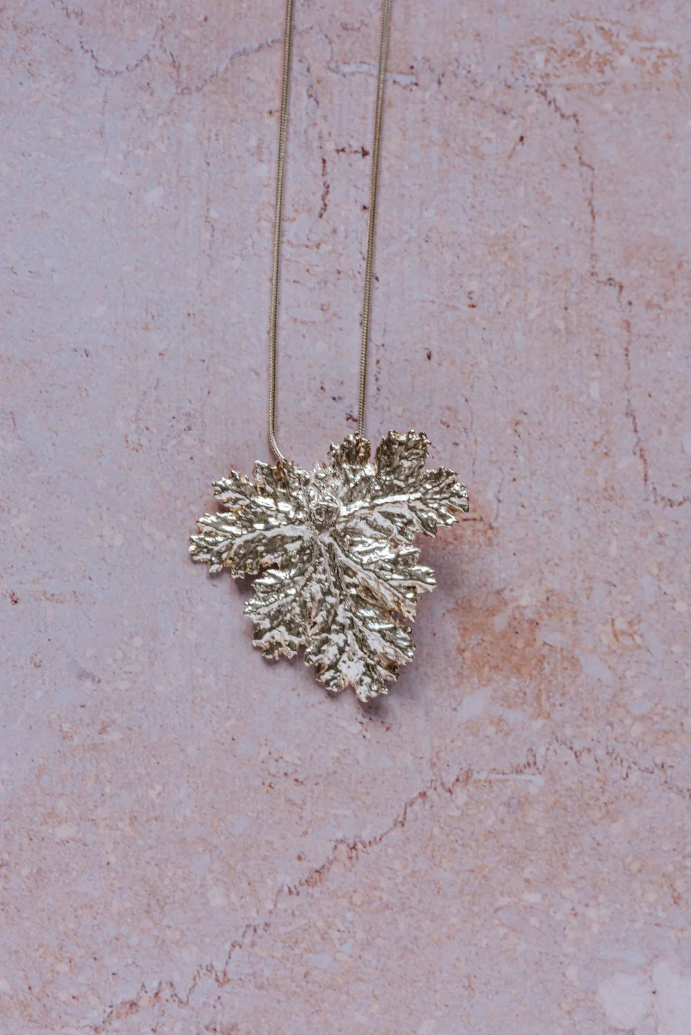 Handcrafted fine silver geranium leaf pendant necklace with intricate natural texture, inspired by Victorian floral symbolism of friendship and gentility.