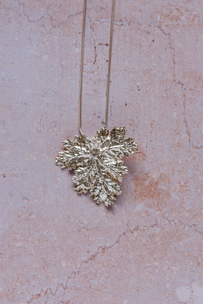 Handcrafted fine silver geranium leaf pendant necklace with intricate natural texture, inspired by Victorian floral symbolism of friendship and gentility.