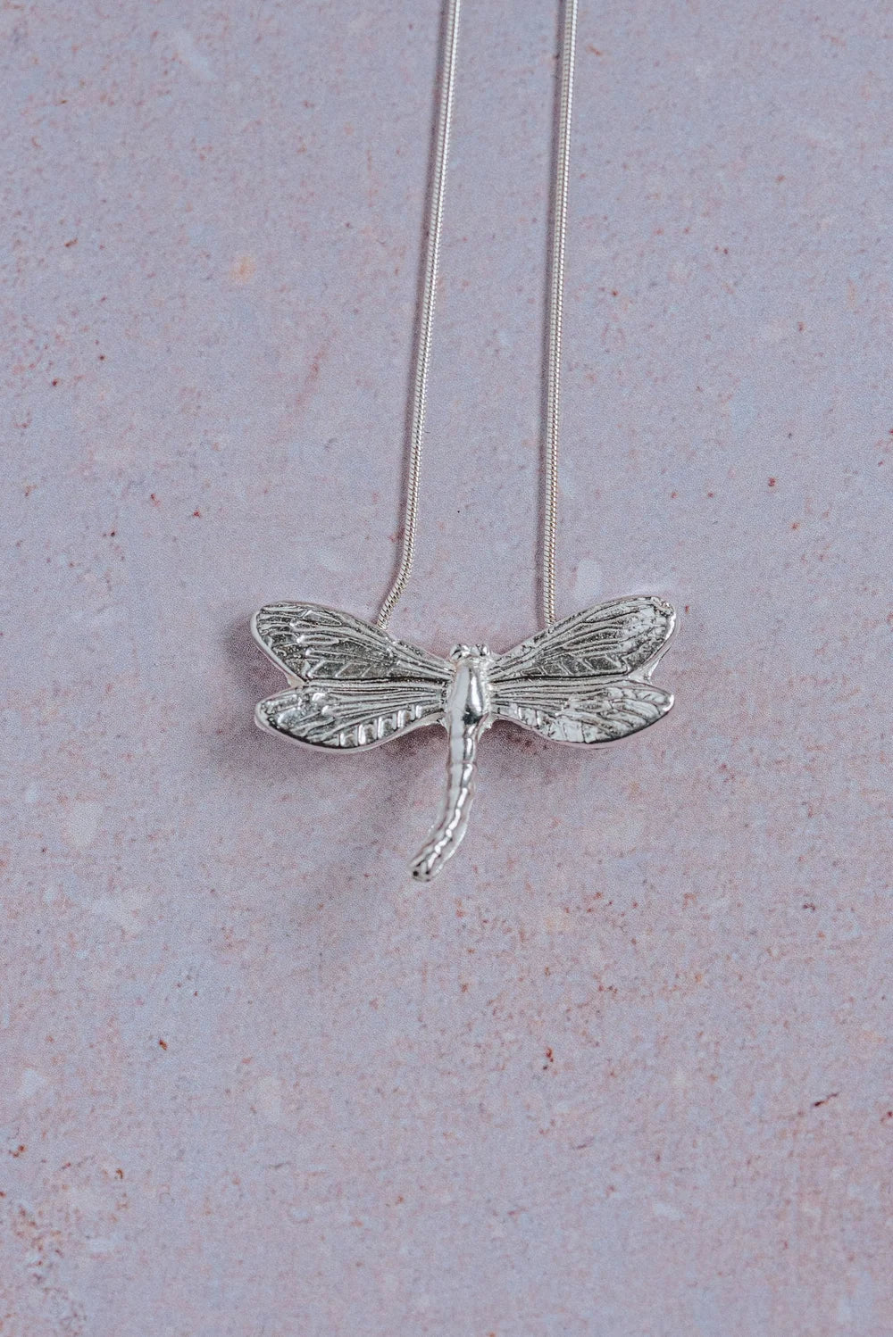 Handmade silver dragonfly pendant necklace with detailed textured wings on sterling silver snake chain