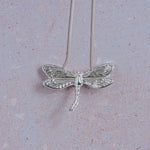 Handmade silver dragonfly pendant necklace with detailed textured wings on sterling silver snake chain