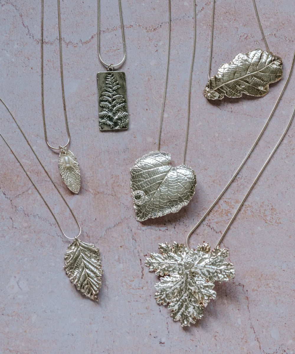 Handmade silver leaf pendants collection featuring heart leaf, oak leaf and fern designs, eco-conscious fine silver jewellery UK
