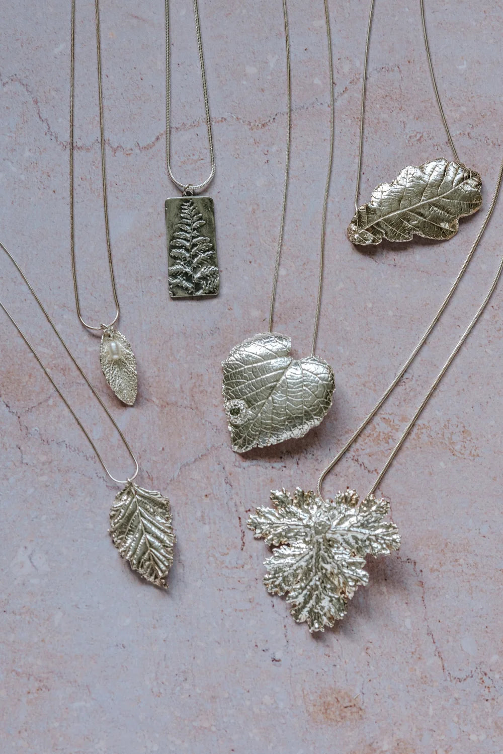Handmade silver leaf pendants collection featuring heart leaf, oak leaf and fern designs, eco-conscious fine silver jewellery UK