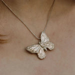 Handmade recycled silver large butterfly pendant worn on 18-inch snake chain, close-up view
