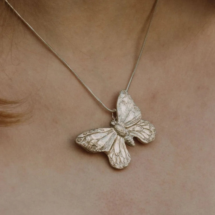 Handmade recycled silver large butterfly pendant worn on 18-inch snake chain, close-up view