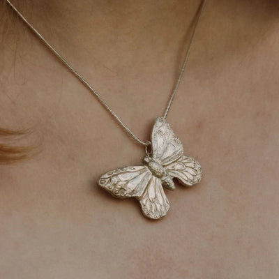 Handmade recycled silver large butterfly pendant worn on 18-inch snake chain, close-up view