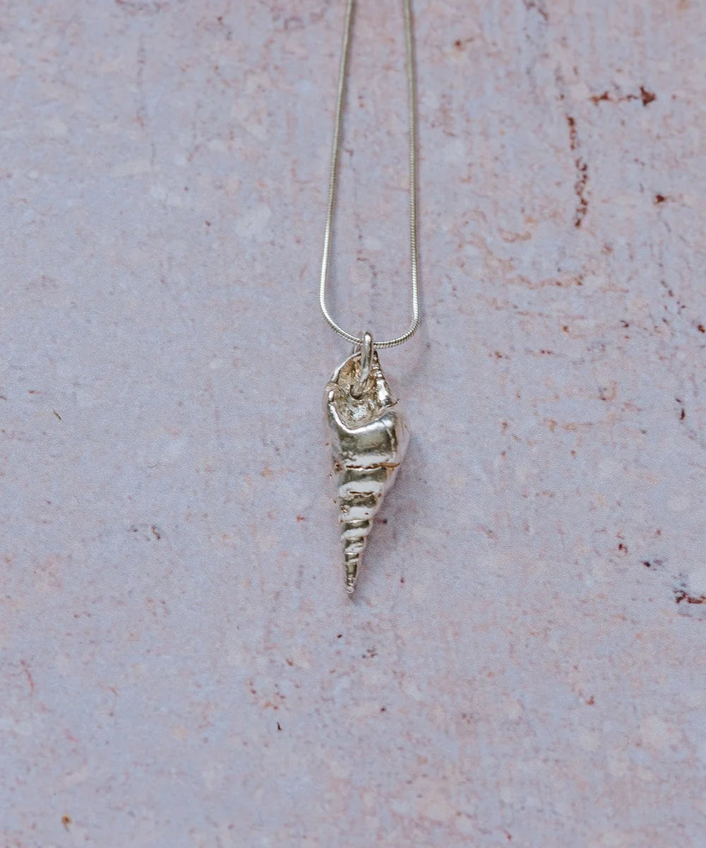 Handmade recycled silver mollusc shell pendant on 16-inch chain, displayed on textured stone background