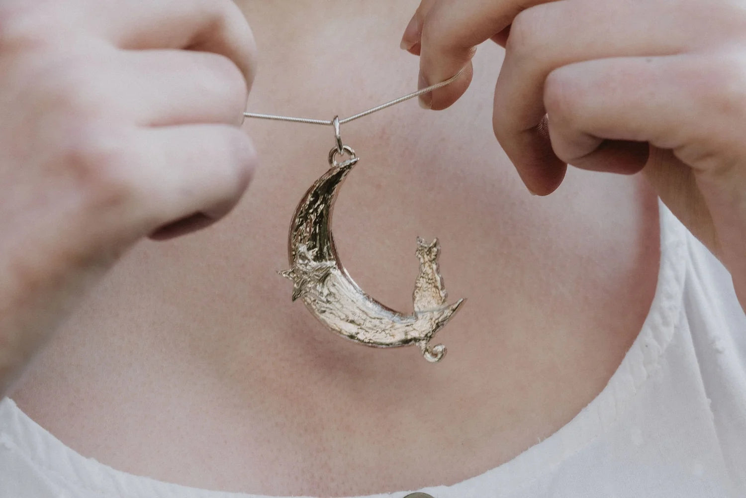 Silver cat moon pendant necklace worn on model showing scale and detail
