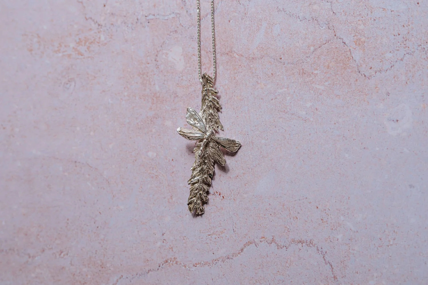 Close-up of handmade silver dragonfly and catkin pendant on sterling chain, artisan botanical jewellery necklace, symbolic nature jewellery gift for her