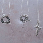 Three handmade silver dragonfly pendants on sterling chains, including moon dragonfly pendant, star dragonfly pendant, and catkin dragonfly pendant, artisan nature inspired jewellery gifts UK