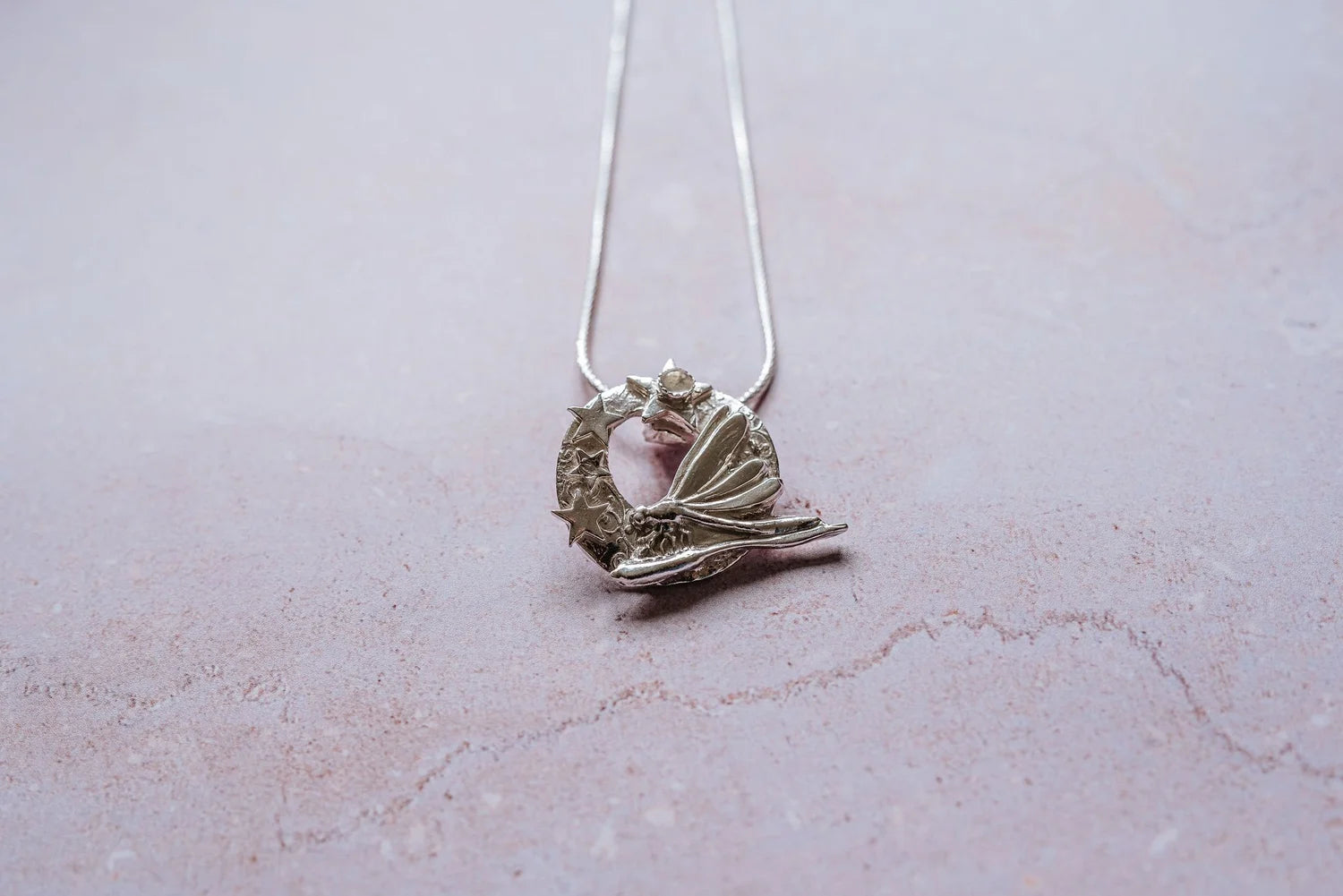 Close-up of handmade silver dragonfly and stars pendant necklace with moonstone cabochon, artisan celestial jewellery gift for women UK