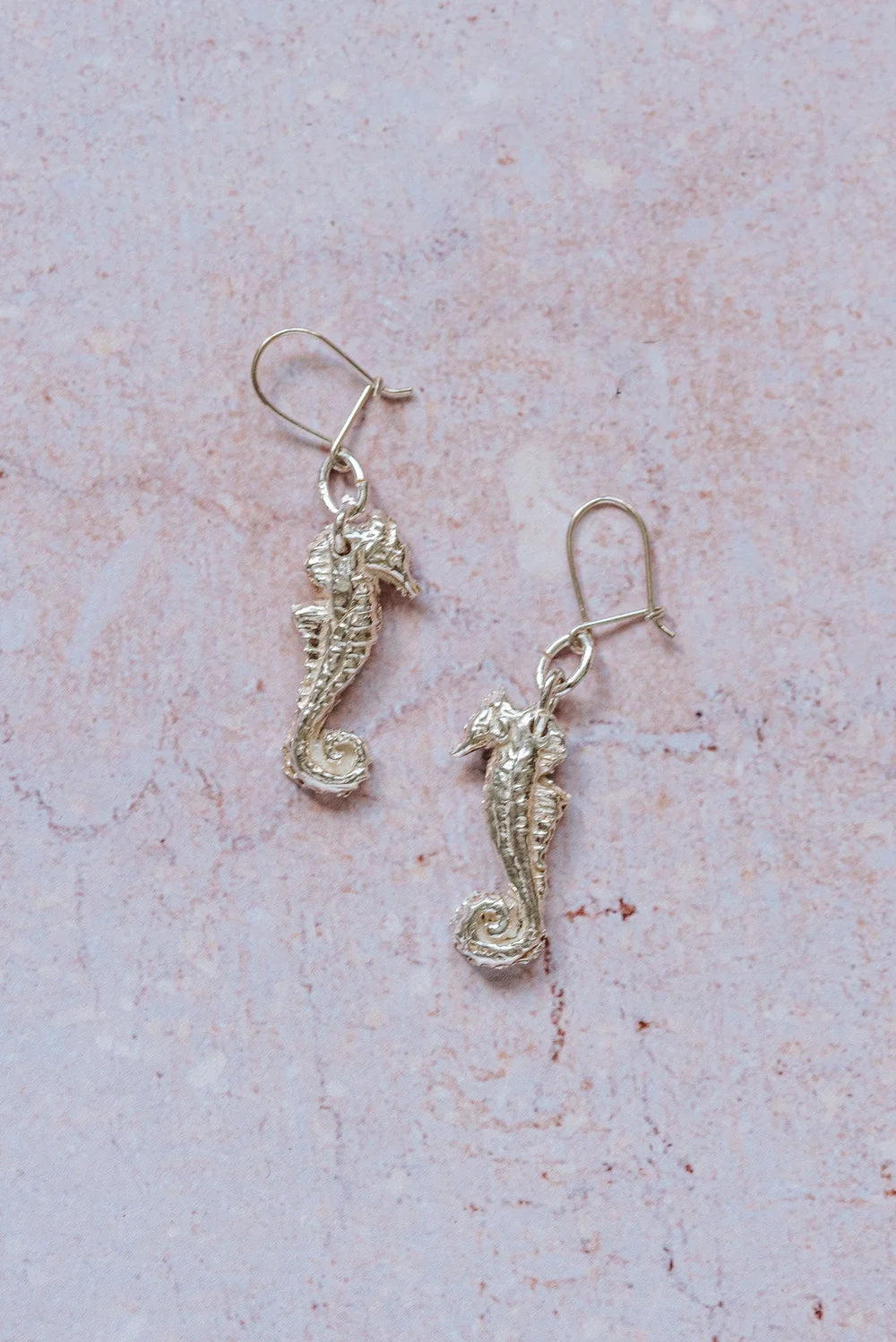 Handmade silver seahorse drop earrings with intricate detailing, part of a coastal inspired jewellery collection.