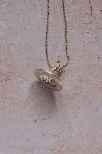 Handmade recycled silver witch hat pendant with tilted tip and floral detail on brim